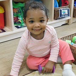 infant girl smiling sitting on floor