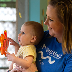 teacher holding baby by window